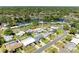 Aerial view of home with a pool and well-kept lawn nestled in a tranquil neighborhood near a lake at 507 Shore Dr, Largo, FL 33771
