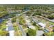Aerial view of home with a pool and well-kept lawn nestled in a tranquil neighborhood near a lake at 507 Shore Dr, Largo, FL 33771