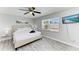 Bedroom with a comfortable bed, ceiling fan, large window, and a TV mounted on the wall at 507 Shore Dr, Largo, FL 33771