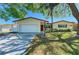 Charming single-story home with a two-car garage, well-kept lawn, and mature trees offering shade at 507 Shore Dr, Largo, FL 33771