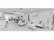 Open-concept living area with white furniture and adjacent dining/game room at 507 Shore Dr, Largo, FL 33771