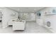 Bright living room featuring white furniture, stylish decor, and light wood-look flooring at 507 Shore Dr, Largo, FL 33771