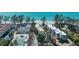 Stunning aerial view of a beachfront home with a private pool and tennis court, framed by lush tropical trees at 5125 Gulf Of Mexico Dr # 4, Longboat Key, FL 34228