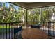 Screened-in balcony featuring seating and a verdant exterior view of greenery and trees at 5125 Gulf Of Mexico Dr # 4, Longboat Key, FL 34228