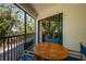 Screened-in balcony featuring seating and lush landscaping on the exterior of the property at 5125 Gulf Of Mexico Dr # 4, Longboat Key, FL 34228