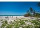 Beautiful beach view with four lounge chairs on the white sand near the ocean on a clear day at 5125 Gulf Of Mexico Dr # 4, Longboat Key, FL 34228