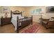 Cozy bedroom with tiled floor, ornate wooden bed frame and night stand with lamp at 5125 Gulf Of Mexico Dr # 4, Longboat Key, FL 34228