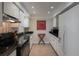 Charming kitchen featuring white cabinetry, black countertops, and modern appliances at 5125 Gulf Of Mexico Dr # 4, Longboat Key, FL 34228