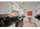 Bright kitchen with white cabinets, black appliances, and a cozy tiled floor at 5125 Gulf Of Mexico Dr # 4, Longboat Key, FL 34228