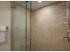 Shower with glass door, large tiles, handheld shower head, and soap and shampoo caddy at 5125 Gulf Of Mexico Dr # 4, Longboat Key, FL 34228