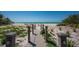 Wooden walkway leading to a beautiful beach with lounge chairs, ocean views, and a clear, sunny sky at 5125 Gulf Of Mexico Dr # 4, Longboat Key, FL 34228