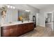 Bathroom boasts double sinks, dark wood cabinetry, and a large mirror reflecting the tiled shower at 5442 Kent Rd, Venice, FL 34293