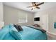 Comfortable bedroom with a blue bed, a ceiling fan, and a view to the outside at 5442 Kent Rd, Venice, FL 34293