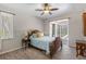 Bedroom features wooden furniture, a ceiling fan, and views of a screened-in porch at 5442 Kent Rd, Venice, FL 34293