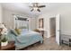 Bright bedroom featuring wood-look tile floors, ceiling fan, and French doors to the screened lanai at 5442 Kent Rd, Venice, FL 34293