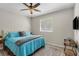 Cozy bedroom with a plush blue bed, neutral walls, and a ceiling fan at 5442 Kent Rd, Venice, FL 34293