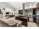 Spacious kitchen featuring a central island with cooktop, stainless steel appliances, stone counters, and ample storage at 5442 Kent Rd, Venice, FL 34293