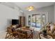 Inviting living room featuring vaulted ceiling and sliding glass doors to the pool area at 5442 Kent Rd, Venice, FL 34293
