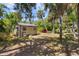 Backyard storage shed amongst mature trees and shrubs offering convenient storage solutions at 5442 Kent Rd, Venice, FL 34293