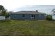 Back exterior of the home featuring a patio and expansive green yard at 5578 Thyer St, North Port, FL 34288