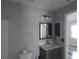 Bathroom with a modern vanity, mirror, toilet, and updated lighting fixtures at 5578 Thyer St, North Port, FL 34288