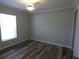 This bedroom features a modern ceiling fan, a light filled window, and beautiful wood-look flooring at 5578 Thyer St, North Port, FL 34288