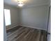 Bedroom featuring wood-look floors, white trim, and a window for natural light at 5578 Thyer St, North Port, FL 34288