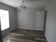 Bedroom featuring wood-look floors, a ceiling fan, and a window for natural light at 5578 Thyer St, North Port, FL 34288