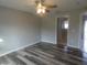 Bedroom with wood-look flooring, ceiling fan, and an open doorway to another room at 5578 Thyer St, North Port, FL 34288