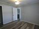 Cozy bedroom with wood-look floors, white trim, and doorway to an en-suite bathroom at 5578 Thyer St, North Port, FL 34288