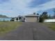 One-story home with a well-kept lawn and a long driveway leading to the attached two-car garage at 5578 Thyer St, North Port, FL 34288