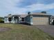 Charming one-story home featuring a well-manicured lawn and an attached two-car garage at 5578 Thyer St, North Port, FL 34288