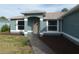 Beautiful entranceway to a cozy home, featuring a tidy lawn and charming landscaping at 5578 Thyer St, North Port, FL 34288