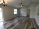 Comfortable living room boasts sleek hardwood floors, a ceiling fan, chandelier, and backyard entrance at 5578 Thyer St, North Port, FL 34288