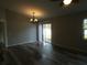 Open living area with wood-look floors, chandelier, and sliding glass doors to the backyard at 5578 Thyer St, North Port, FL 34288