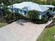 Overhead view of home with lush landscaping, circular paver driveway, and large windows at 5608 Holmes Blvd, Holmes Beach, FL 34217