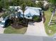 Aerial view of home with mature landscaping, brick driveway, and lush green lawn at 5608 Holmes Blvd, Holmes Beach, FL 34217