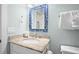 Bright bathroom featuring a granite vanity and a blue mirror at 5608 Holmes Blvd, Holmes Beach, FL 34217