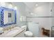 Bright bathroom featuring a shower with glass door and granite vanity with blue mirror at 5608 Holmes Blvd, Holmes Beach, FL 34217