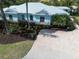 Stunning coastal home with lush landscaping, beautiful paver driveway, and a stylish light blue exterior at 5608 Holmes Blvd, Holmes Beach, FL 34217