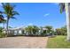 Charming single-story home featuring a paver driveway, tropical landscaping, and a light-colored exterior paint at 5608 Holmes Blvd, Holmes Beach, FL 34217