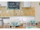 Kitchen features stainless appliances, granite countertops, travertine backsplash, and welcome chalkboard at 5608 Holmes Blvd, Holmes Beach, FL 34217