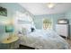 Bedroom with bright turquoise walls with queen size bed and dresser with TV at 5608 Holmes Blvd, Holmes Beach, FL 34217