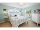 Bedroom with bright turquoise walls with queen size bed and dresser with TV at 5608 Holmes Blvd, Holmes Beach, FL 34217