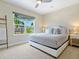 Bright bedroom featuring a bed with throw pillows and a view of the neighborhood at 5742 Hydrangea Cir, Sarasota, FL 34238