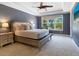 Serene main bedroom with neutral tones, a king-size bed, and views of the pool area at 5742 Hydrangea Cir, Sarasota, FL 34238