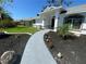 Inviting front entrance with a light gray walkway and beautifully landscaped flower beds at 5810 42Nd E St, Bradenton, FL 34203