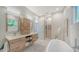 Spa-like bathroom with double vanities, a soaking tub, and walk-in closet access creating a serene retreat at 5856 Meriwether Pl, Sarasota, FL 34232