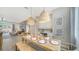 Elegant dining area with stylish light fixtures, seating, and view into living room, creating a warm and inviting atmosphere at 5856 Meriwether Pl, Sarasota, FL 34232