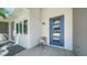 Contemporary style home features a blue front door, natural stone, and a modern window at 5856 Meriwether Pl, Sarasota, FL 34232